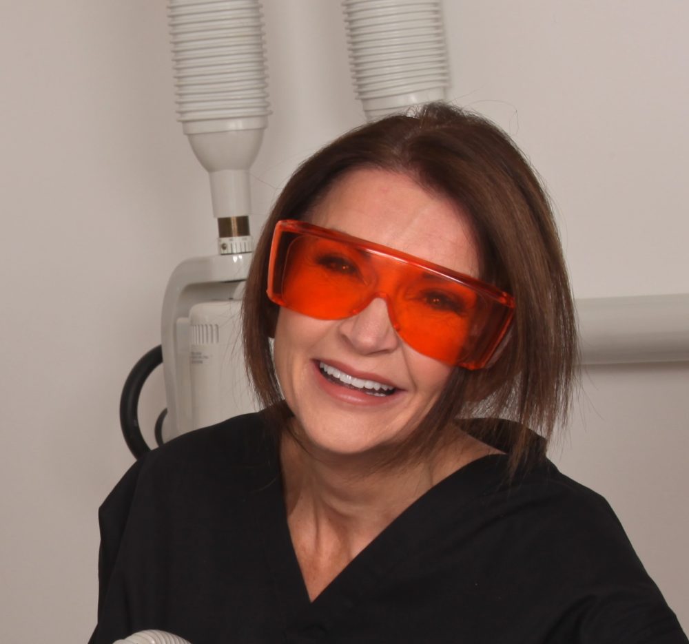 Dr Tracey Bell, pictured at work, warns of the dangers of dermal fillers
