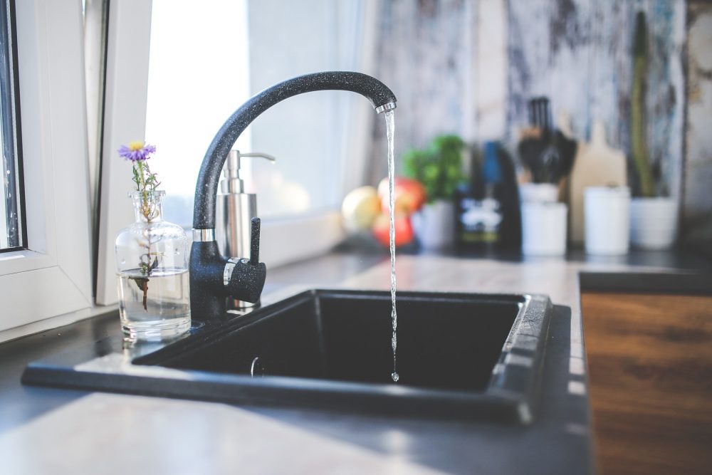 Black sink pictured with tap running