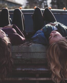 women with long hair chatting on a vintage car